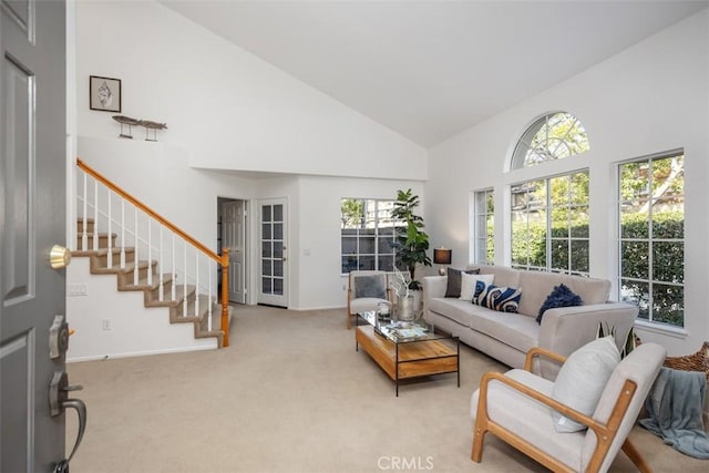 living room with plenty of natural light, light colored carpet, and high vaulted ceiling