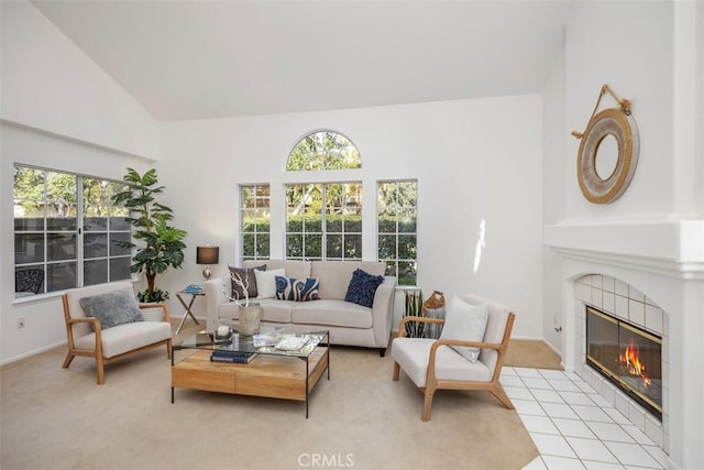 carpeted living room featuring a tile fireplace and vaulted ceiling