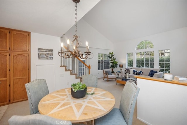 dining area featuring a notable chandelier and high vaulted ceiling