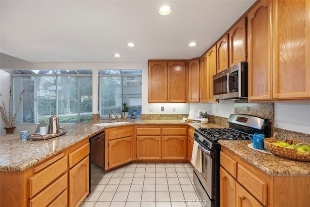 kitchen featuring sink, light tile patterned floors, stainless steel appliances, and light stone countertops