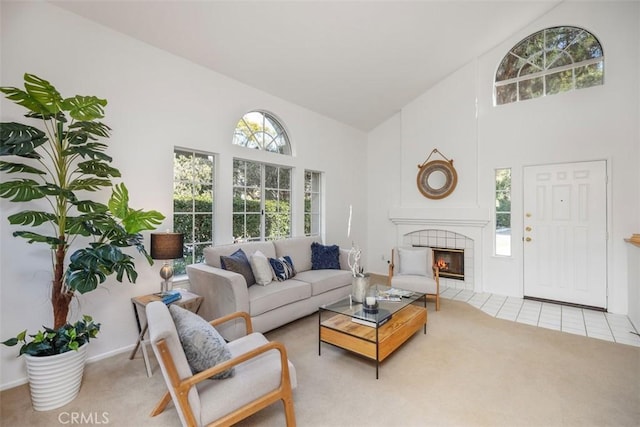 living room with high vaulted ceiling, a fireplace, and light colored carpet