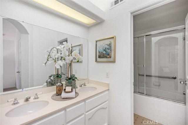 bathroom with tile patterned flooring, bath / shower combo with glass door, and vanity