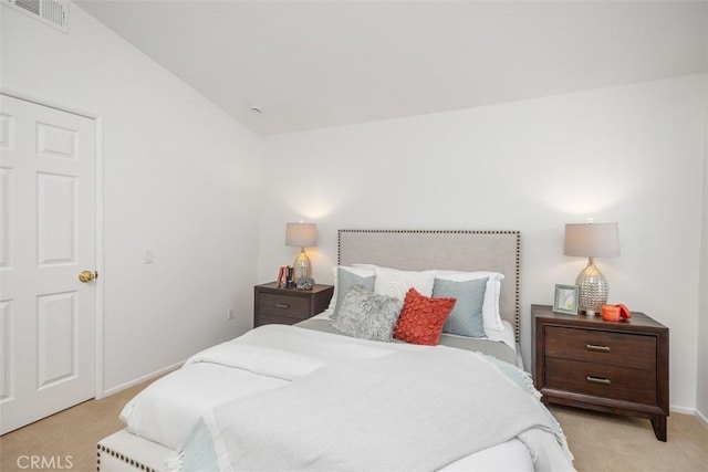 bedroom featuring lofted ceiling and light colored carpet