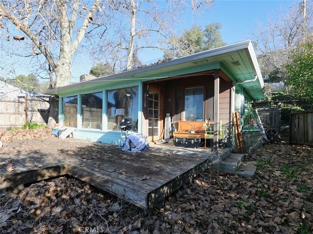 rear view of property with a deck and a sunroom