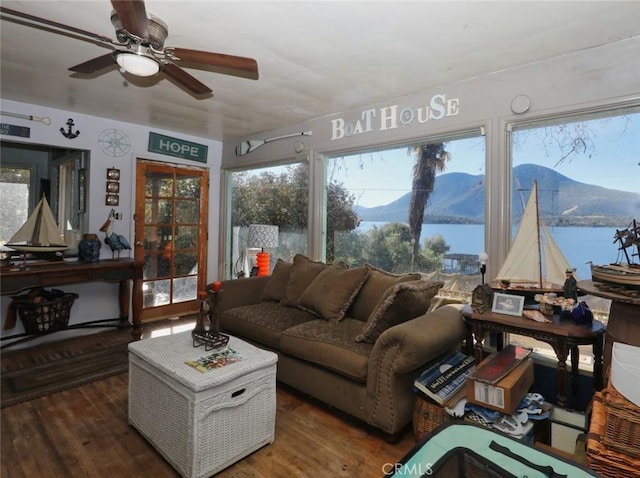 sunroom featuring a water and mountain view and ceiling fan