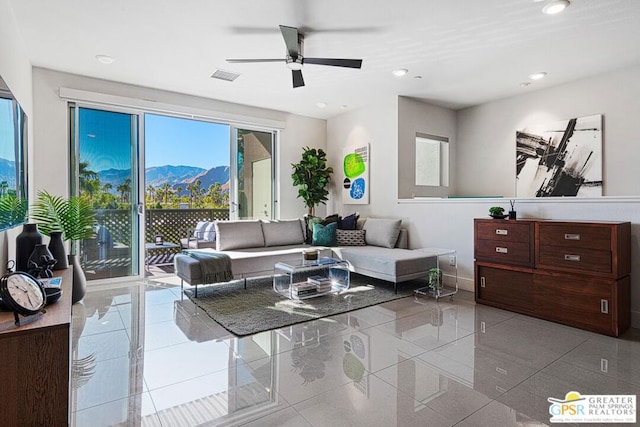 living room featuring ceiling fan, light tile patterned floors, and a mountain view