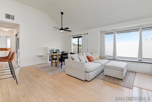 living room featuring ceiling fan, light hardwood / wood-style flooring, and lofted ceiling