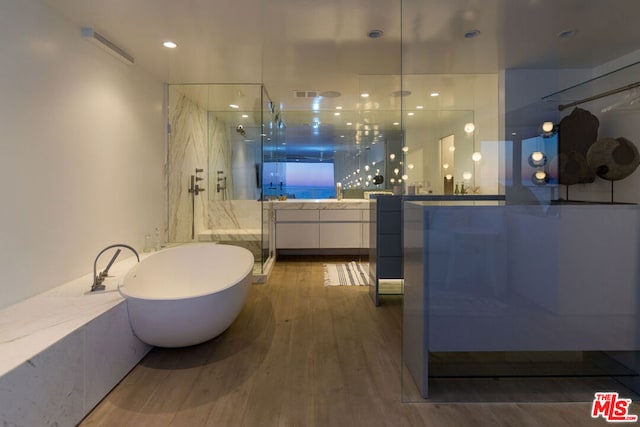 bathroom featuring hardwood / wood-style flooring, vanity, and shower with separate bathtub