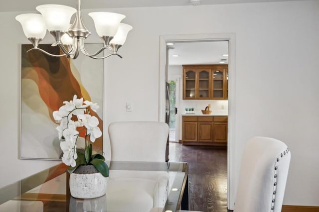 dining area with an inviting chandelier and dark wood-type flooring