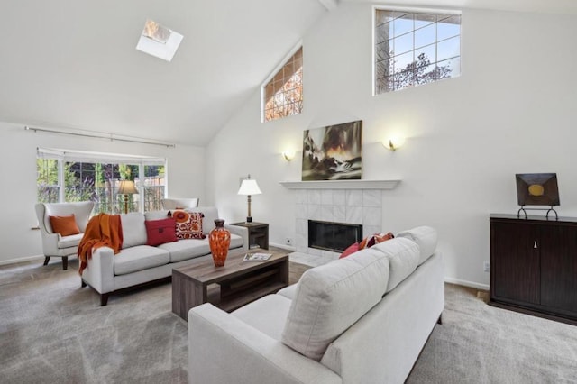 carpeted living room with high vaulted ceiling, beam ceiling, a skylight, and a tile fireplace