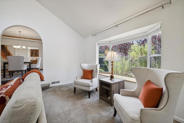 living area featuring lofted ceiling, carpet floors, and an inviting chandelier