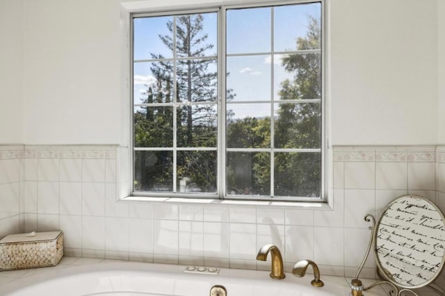 bathroom featuring tile walls, a bath, and a wealth of natural light