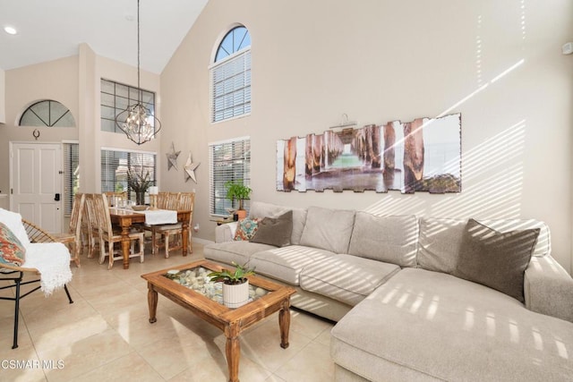 tiled living room with a notable chandelier and high vaulted ceiling