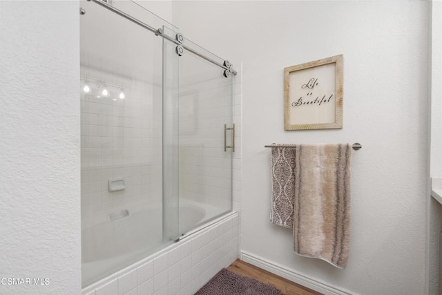 bathroom with bath / shower combo with glass door