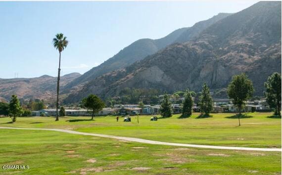 view of home's community featuring a mountain view and a yard