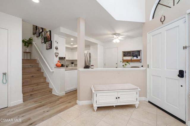 kitchen featuring white cabinetry, kitchen peninsula, stainless steel refrigerator, ceiling fan, and light tile patterned floors