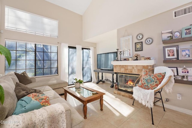 sitting room with a tiled fireplace and light tile patterned flooring