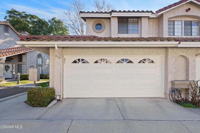 mediterranean / spanish home featuring a garage