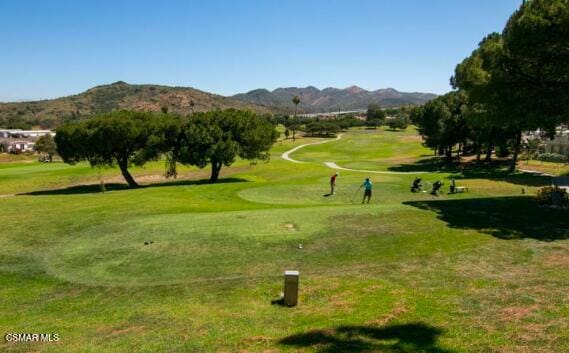 surrounding community with a mountain view and a yard