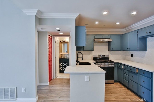 kitchen featuring sink, kitchen peninsula, stainless steel range with gas cooktop, crown molding, and blue cabinets