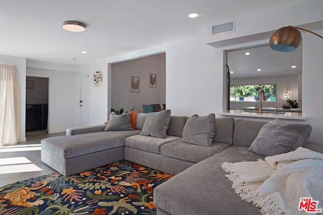 living room featuring washer / clothes dryer and sink