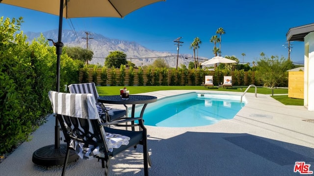 view of swimming pool with a mountain view and a patio area