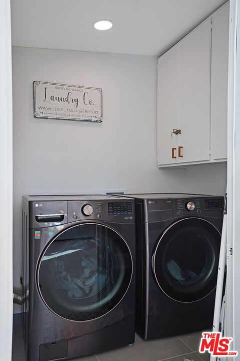 washroom with cabinets, separate washer and dryer, and tile patterned floors