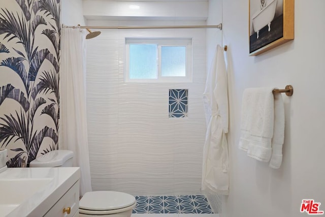 bathroom with toilet, vanity, and curtained shower