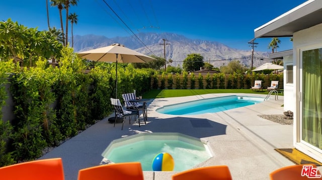 view of swimming pool featuring a mountain view and an in ground hot tub