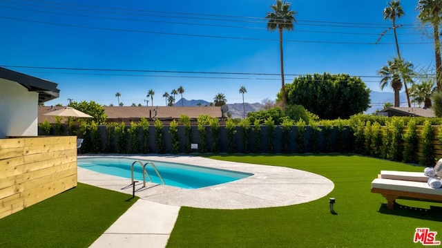 view of swimming pool featuring a yard