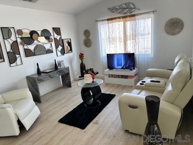 living room with lofted ceiling and light wood-type flooring