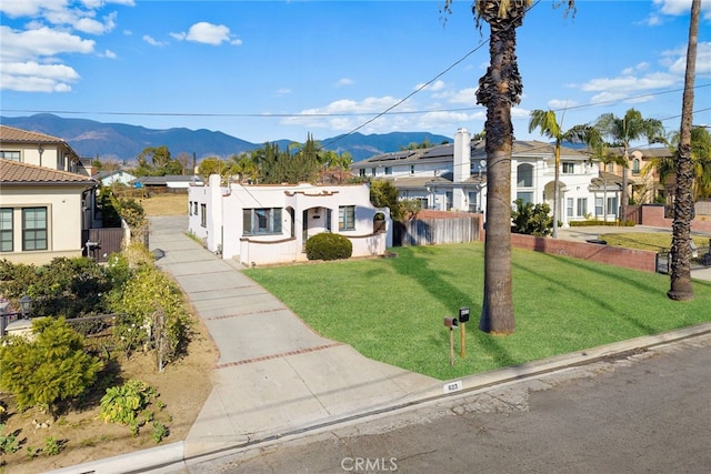 view of front of home with a mountain view and a front yard