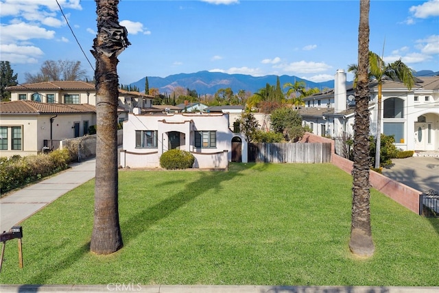 view of front of property featuring a front lawn and a mountain view