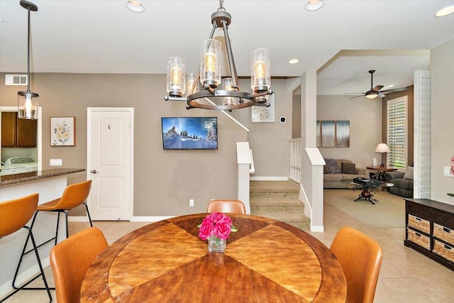 dining area with ceiling fan with notable chandelier