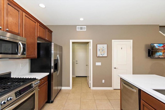 kitchen with light tile patterned floors and stainless steel appliances