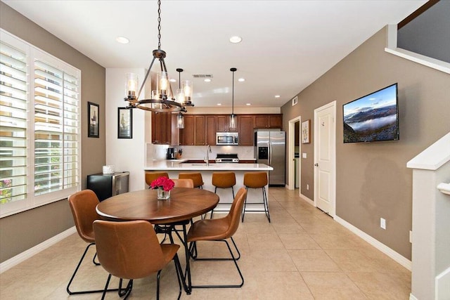 dining space with sink, a chandelier, and light tile patterned flooring