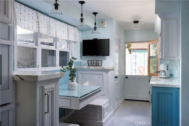 kitchen with hanging light fixtures, white cabinets, and blue cabinets