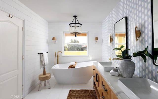 bathroom featuring an inviting chandelier, tile patterned floors, a tub to relax in, and vanity