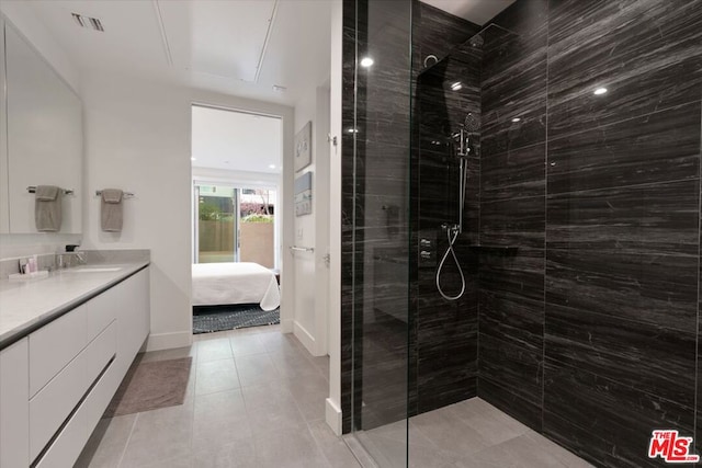 bathroom featuring tiled shower and vanity