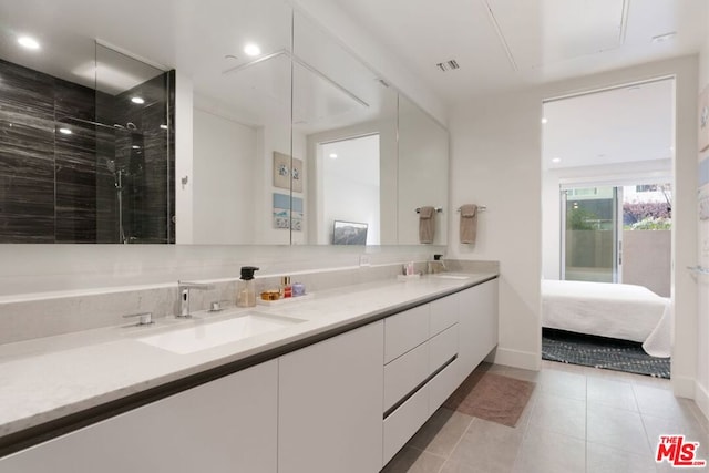 bathroom with vanity, tile patterned flooring, decorative backsplash, and a tile shower