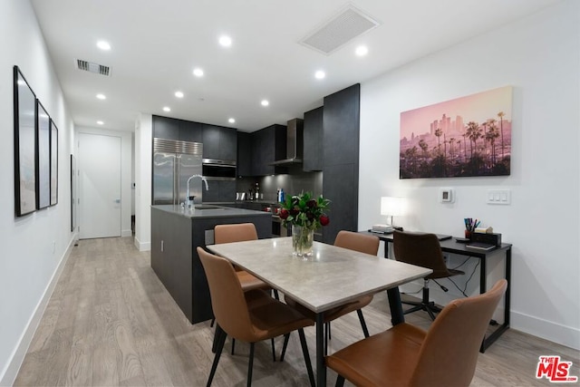 dining space with light wood-type flooring and sink