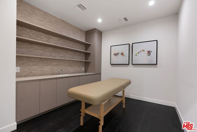 home office with bar and dark wood-type flooring