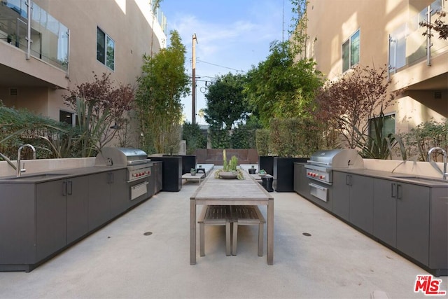 view of patio / terrace featuring a grill, exterior kitchen, and sink