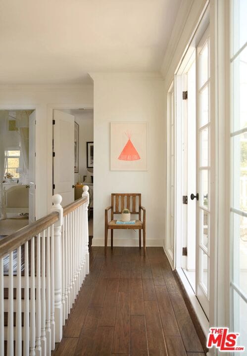 hall featuring dark wood-type flooring and ornamental molding