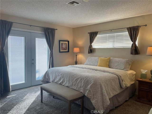 carpeted bedroom with multiple windows, access to outside, french doors, and a textured ceiling