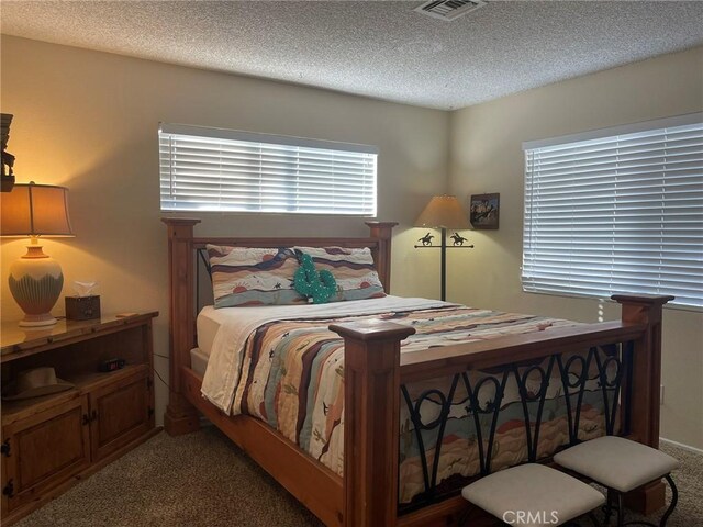 bedroom with a textured ceiling and carpet flooring