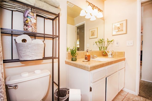 bathroom with toilet, vanity, and tile patterned flooring