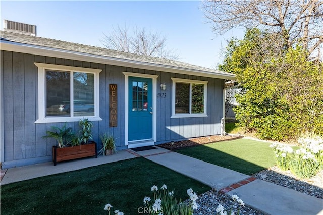 view of exterior entry with a yard