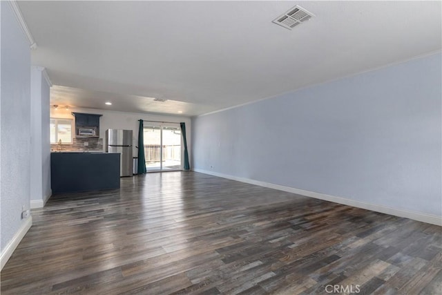 unfurnished living room featuring crown molding, dark hardwood / wood-style flooring, and sink