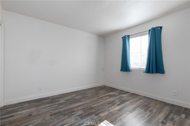 spare room featuring dark wood-type flooring